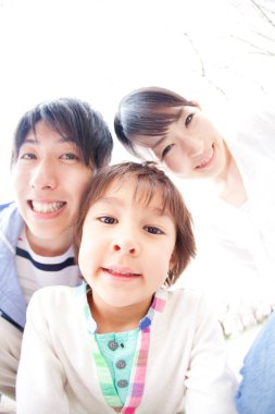 Mutlu Japon ailesinin bahar parkındaki portresi.