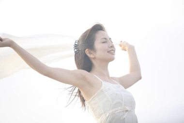 Sahilde beyaz elbiseli güzel bir kadın.