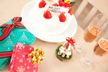 Noel pastası, hediye kutuları ve şampanya masada.