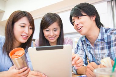 Üniversite kantininde tablet kullanan Asyalı öğrencileri kapatın.