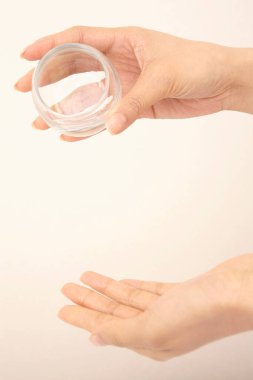 Kadın eli yağ kavanozunu tutuyor. kozmetik ürünü