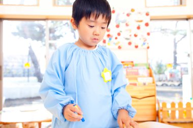 Anaokulunda oynayan Asyalı çocuk.