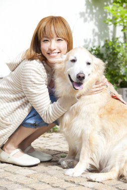 Golden retriever köpeği olan güzel Asyalı bir kadın.