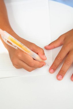 Bir çocuğun ellerinin kağıda kalemle yazışının yakın görüntüsü 