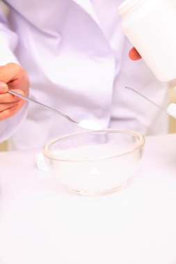 Eczanede ilaç karıştıran laboratuvar önlüklü eczacı.