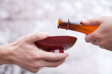 Birisi seramik fincana bira döküyor.