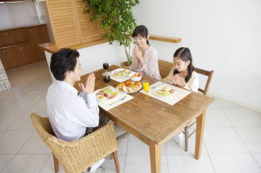 Aile yemekten önce yemek masasında dua eder.