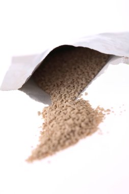 Granüller açık beyaz paketten dökülüyor