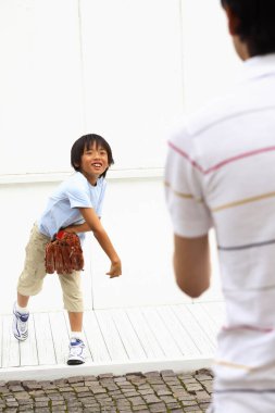 Aktif Asyalı çocuk dışarıda beyzbol oynuyor.