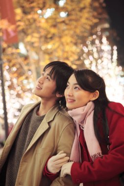 Genç Asyalı bir çiftin Noel panayırında birbirine aşık portresi. 