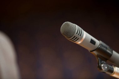 Sahnede konser salonunun arka planındaki mikrofonun yakın görüntüsü         
