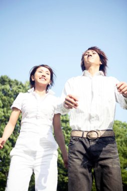 Genç Asyalı çift parka atlıyor.