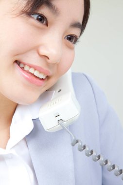 Ofiste telefon kullanan Asyalı iş kadını.