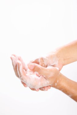 Adam beyaz arka planda sabunla ellerini yıkıyor. 