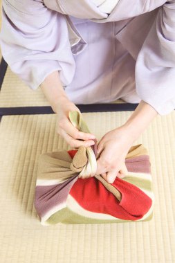 Geleneksel kimonolu Japon kadının kumaşla paketlenmiş bir fotoğrafı. Furoshiki tekniği.