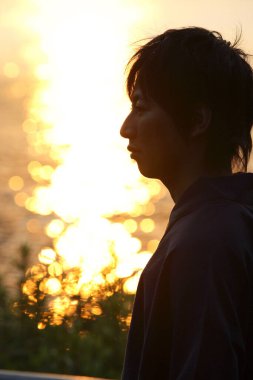 Deniz batımına karşı genç bir Asyalının profil portresi