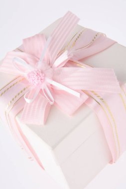 Beyaz arka planda pembe kurdeleli beyaz hediye kutusu
