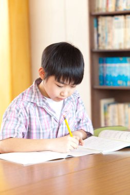 Sıkıcı Japon okul çocuğu sınıfta oturuyor.