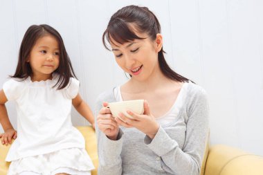 Kız izlerken kadın çaydan zevk alıyor