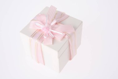 Beyaz arka planda pembe kurdeleli beyaz hediye kutusu