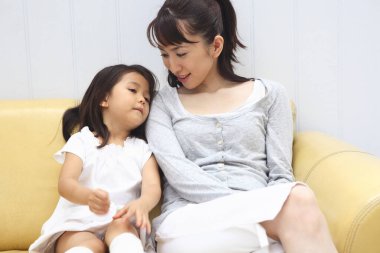 happy mother and daughter  on sofa at home