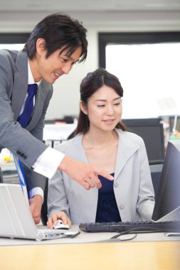 Bir adam ve bir kadın bilgisayar ekranına bakıyor.