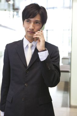 Takım elbiseli bir adam cep telefonuyla konuşuyor.