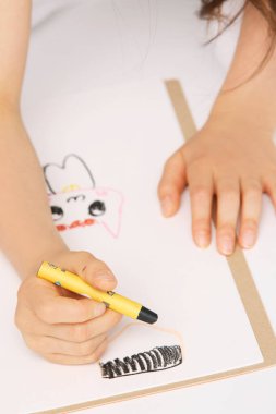 Kadın yere kalemle resim çiziyor.