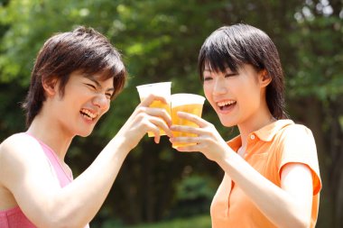 Parkta içki içen iki Asyalı arkadaş. 