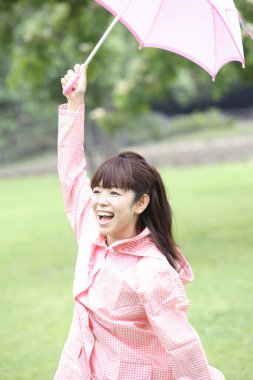 Şemsiyeli mutlu Asyalı kadın