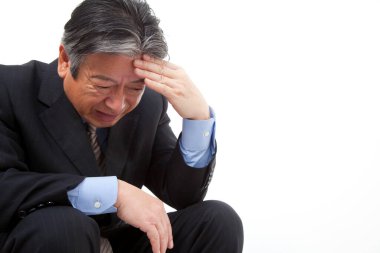 Basamaklarda oturan takım elbiseli stresli bir adam.