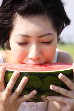 Piknikte karpuz yiyen Asyalı kadını kapat. 