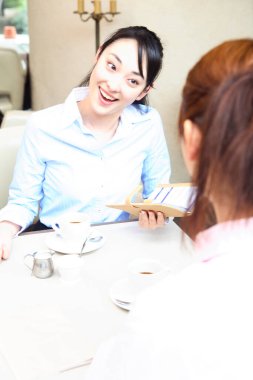 Kafe masasında konuşan iki kadın.