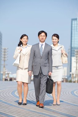 Yakışıklı Japon işadamının portresi. Sokakta poz veren iki iş kadını.