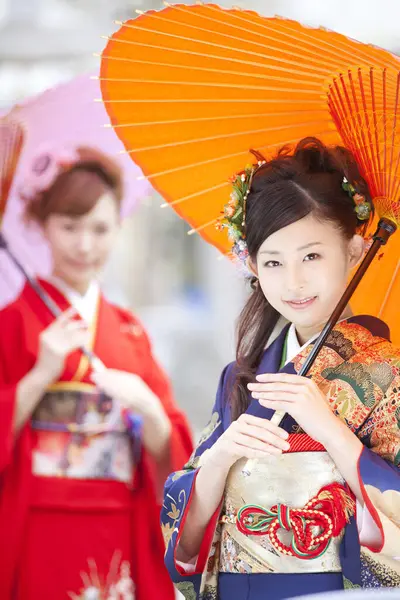 Şemsiyeli kimono giyen güzel Japon kızları. 