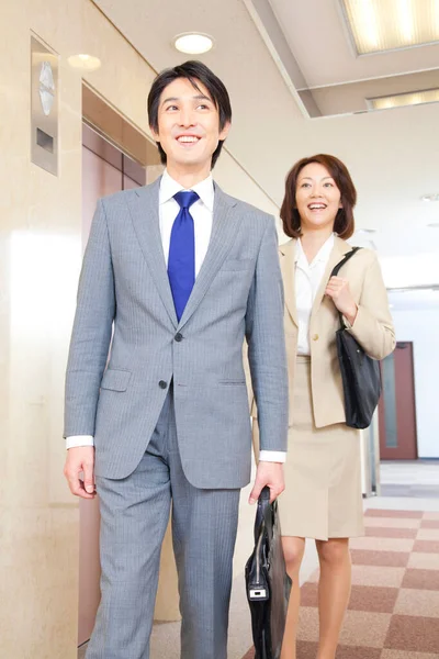 Pewni Siebie Japońscy Biznesmeni Stojący Korytarzu — Zdjęcie stockowe