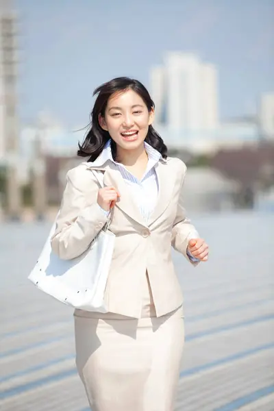 a woman in a business suit is walking on street