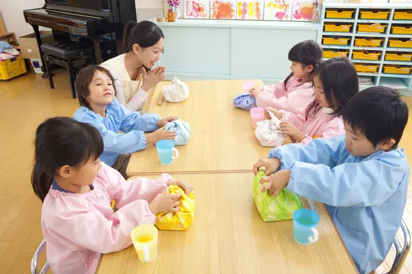 Kleuterleidster Kinderen Zitten Aan Tafel Tijdens Lunch — Stockfoto