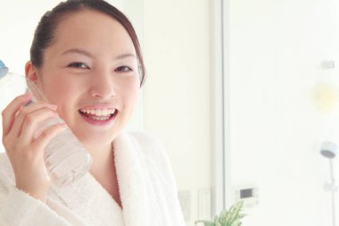 Banyoda suyu olan gülümseyen genç kadın.