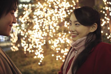 Genç kadın ve erkek kışın ışıklara karşı 