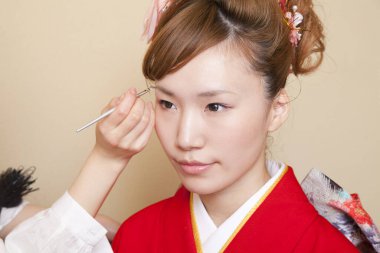 Genç Asyalı kadın makyaj yapıyor.