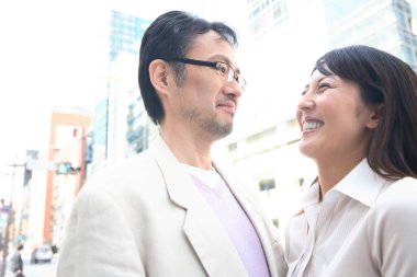 Bir adam ve bir kadın şehirde duruyor.