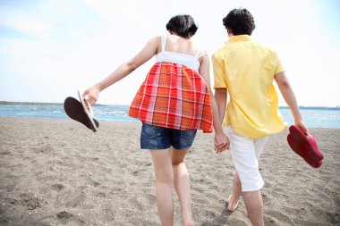 Kumsalda el ele tutuşan mutlu çift