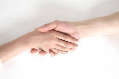 Beyaz bir yüzey üzerinde birbirini sallayan iki el. 