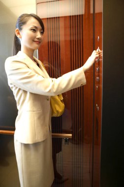 Asansörde düğmeye basan genç kadın