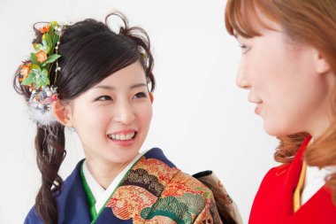 two young asian women in traditional clothing posing on white studio background. traditional japanese style clipart