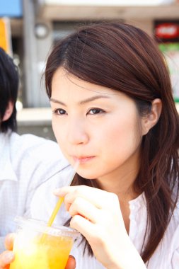 Bir kadın pipetle içki içiyor.