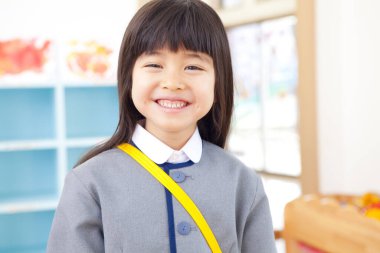 İlkokulda üniforma giyen sevimli küçük bir kız.