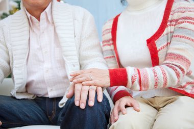 Yaşlı çift el ele tutuşuyor.