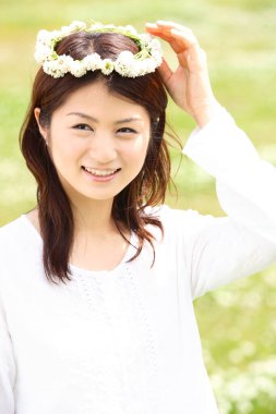 Yaz parkında çiçekli güzel bir Asyalı kadın.